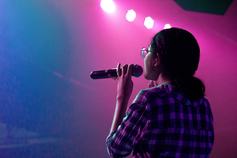 A woman speaking confidently with a microphone