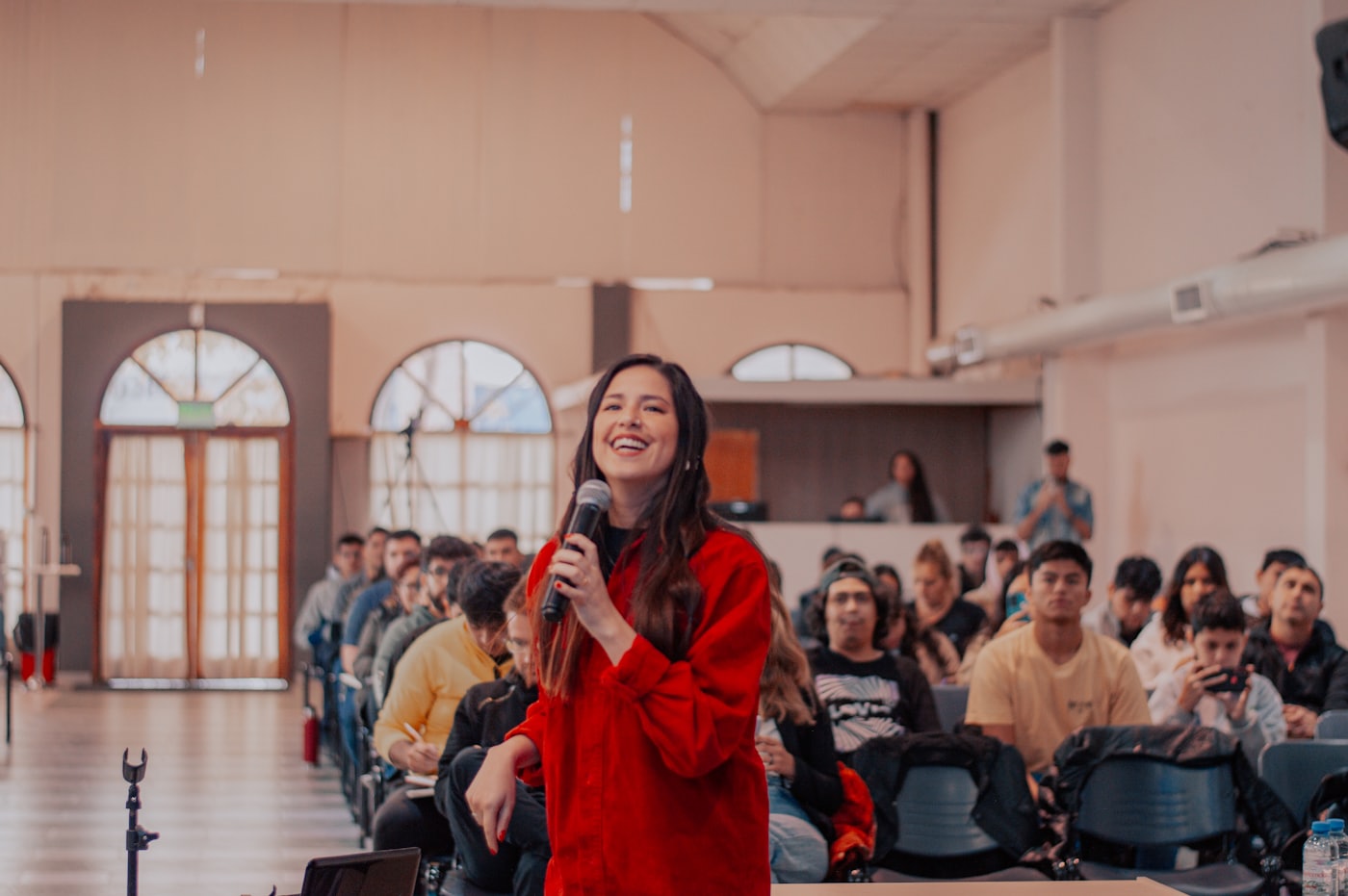 A woman addressing a crowd while holding a microphone